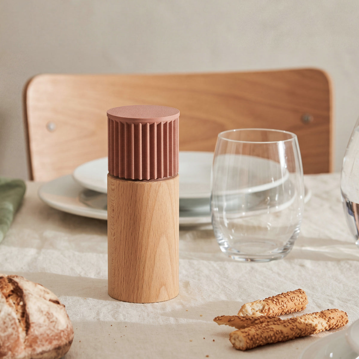 Gewürzmühle Prise in Terracotta aus Buchenholz auf gedecktem Tisch mit Brot und Wasserglas #farbe_terracotta