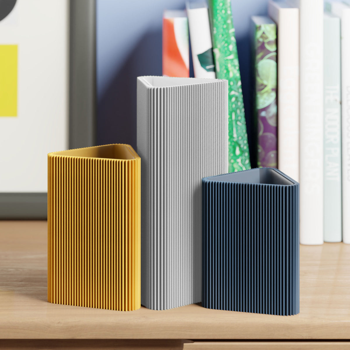 Geometrische Vase DREIECK in hellgrau mit zwei weiteren Vasen vor Büchern im Regal #farbe_hellgrau