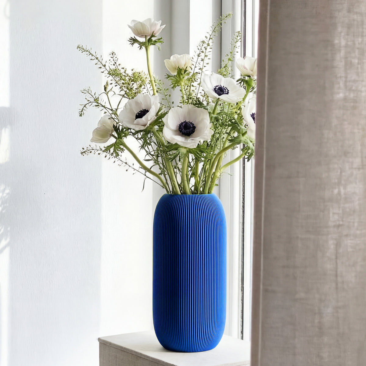 Geriffelte Vase Pille in blau mit weißen Anemonen auf einer Fensterbank #farbe_blau