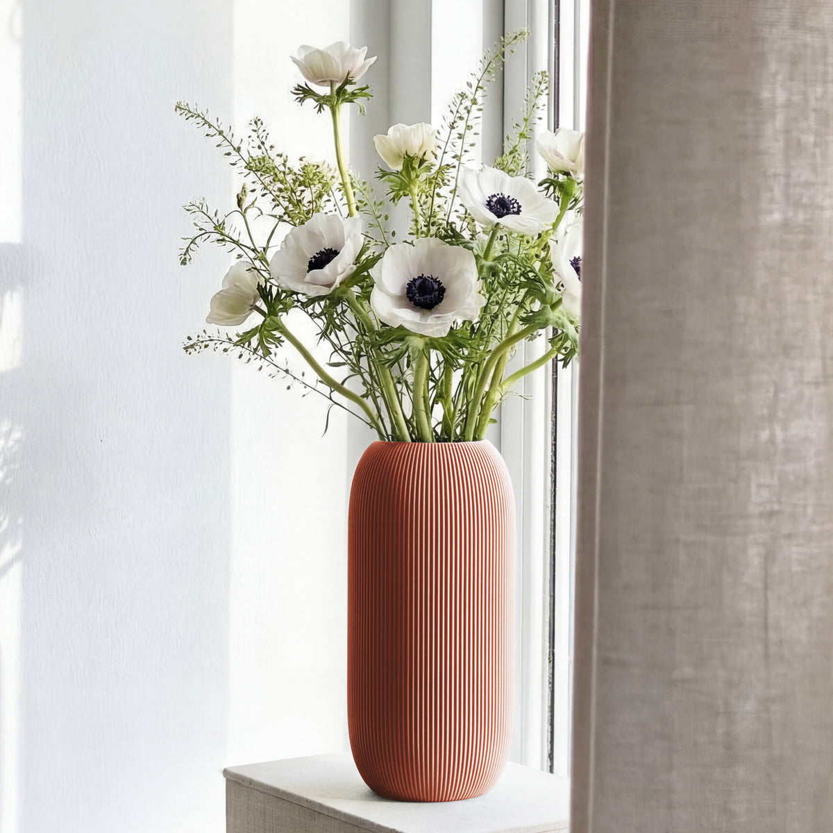 Geriffelte Vase Pille in terracotta mit weißen Anemonen auf einer Fensterbank #farbe_terracotta