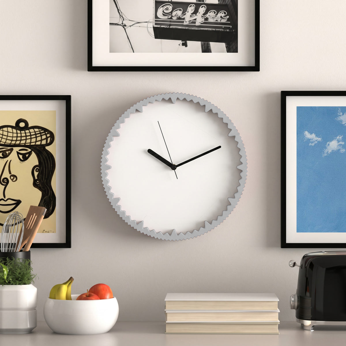 Moderne Wanduhr hellgrau mit gezacktem Rand aus dem 3D Druck an Küchenwand mit Bilderrahmen #farbe_hellgrau
